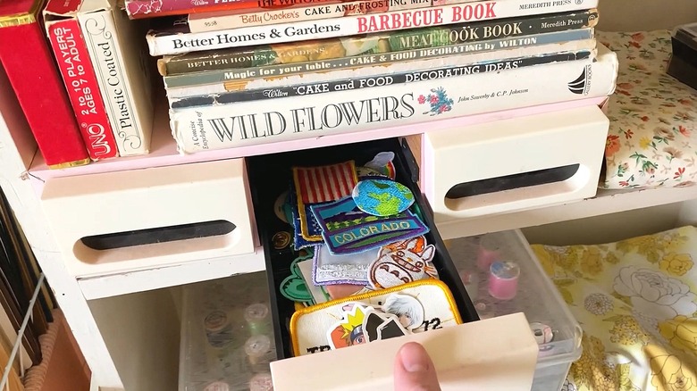 Cassette tape holder with middle drawer open to show patches