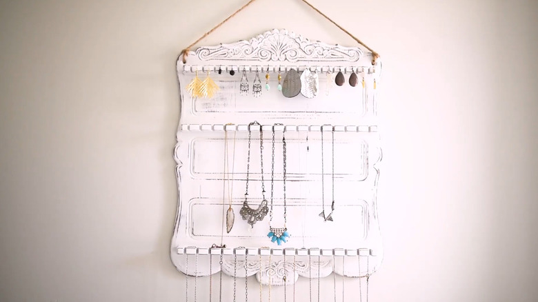 Spoon holder refinished in a distressed white paint and turned into a hanging jewelry rack