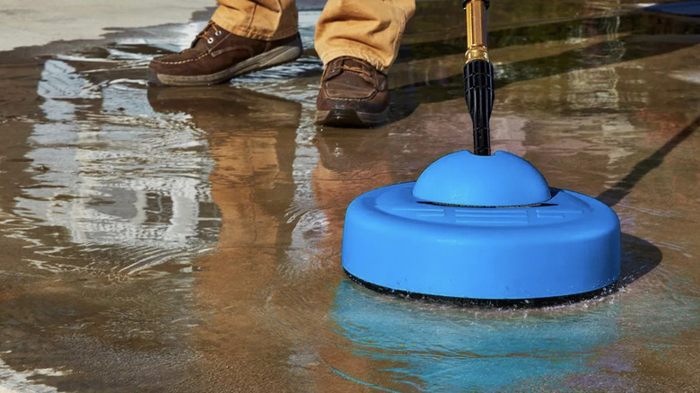 A man uses the 2000 PSI surface cleaner to clean a driveway