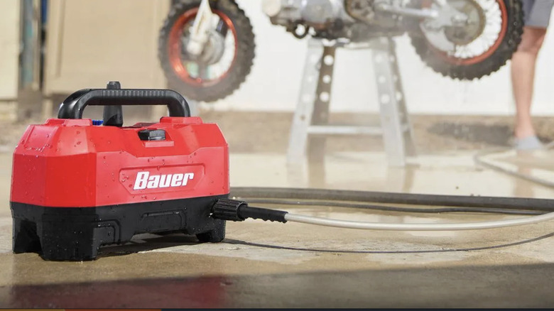 Baur's 1800 PSI electric power washer  helps a man wash a motorcycle