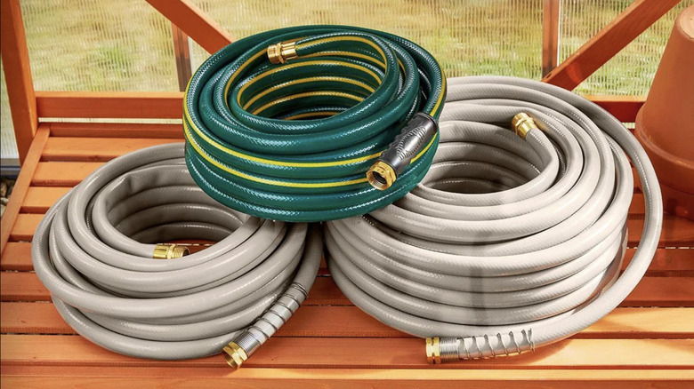 Greenwood's 100-foot contractor garden hose next to two smaller sizes