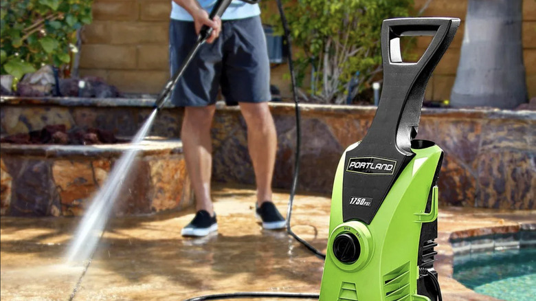 A man washes off pool stone with Portland's 1750 PSI corded electric pressure washer