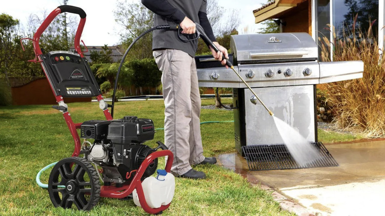 A man uses Predator's 2650 PSI pressure washer to clean a patio