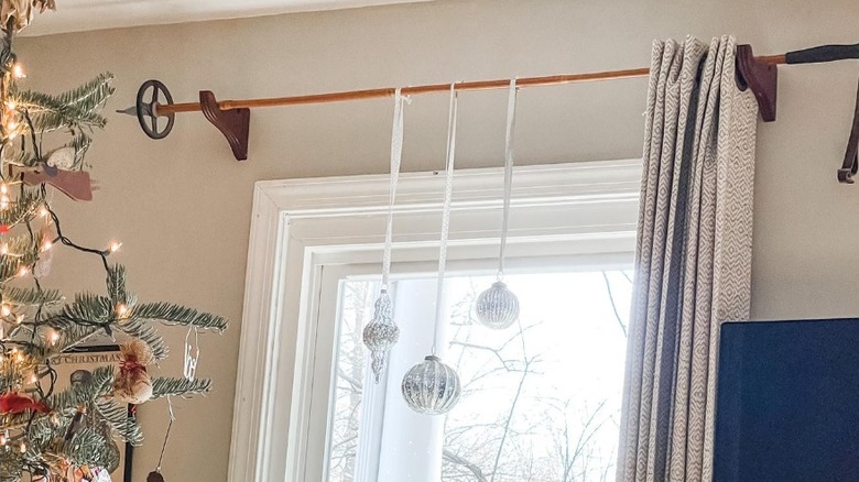 A ski pole holding curtains and decorations.