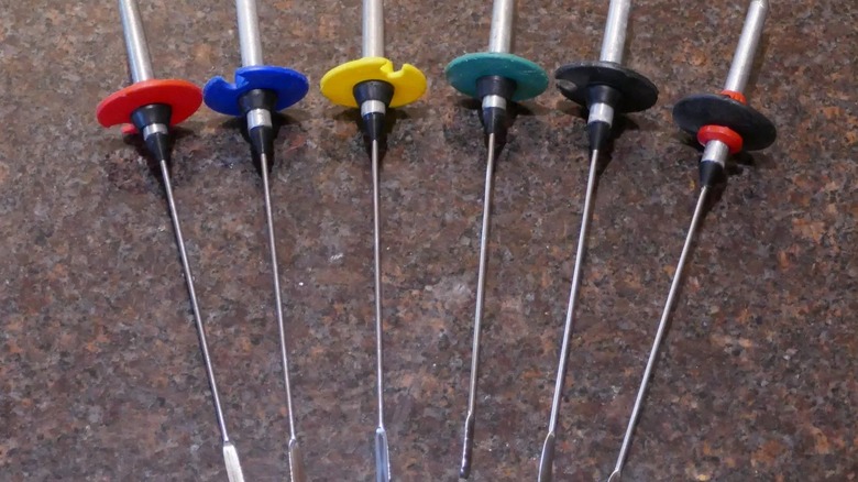 A row of colorful ski pole baskets on drink stirrers.