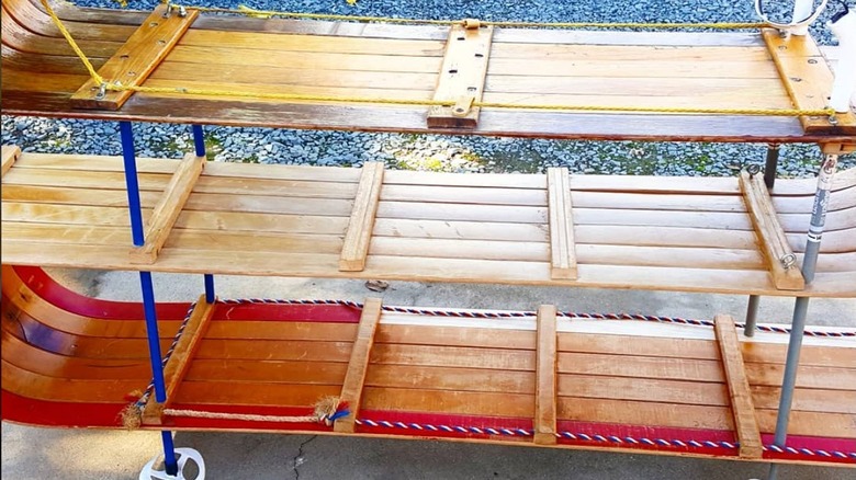 A shelving unit made from ski poles and sleds.