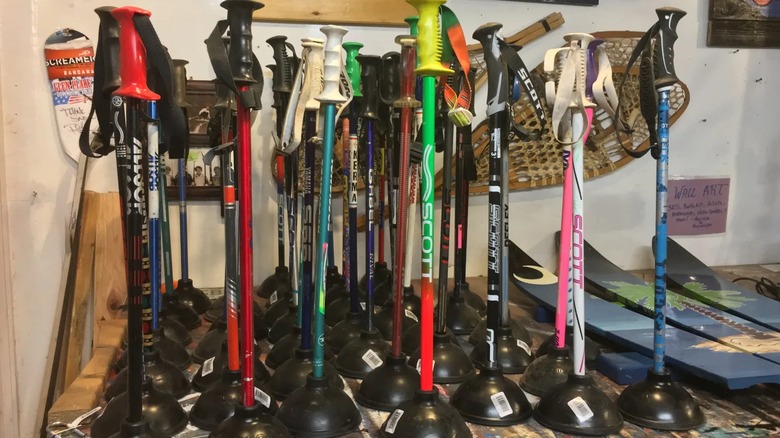 Rows of ski pole toilet plungers on a table.