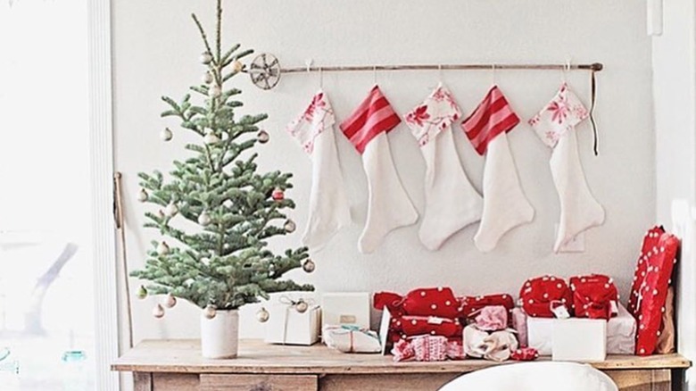 A ski pole holding five Christmas stockings.