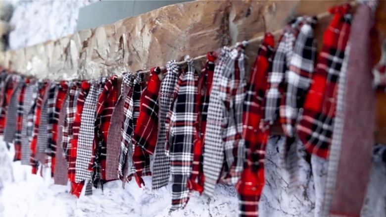 A garland made of strips of a flannel shirt hanging on a mantel