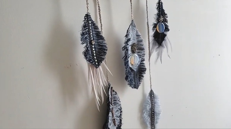 Denim feathers attached to twine on a wall hanging