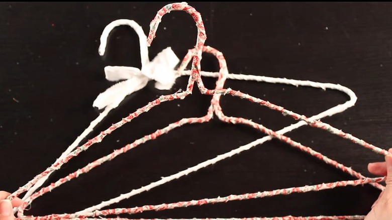 Three fabric-wrapped hangers laying on a black background