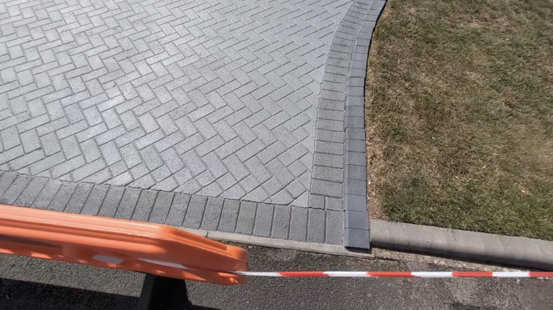 A paved driveway painted in various shades of gray.