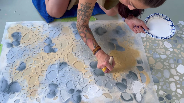 A concrete driveway painted in many colors to resemble terrazzo.