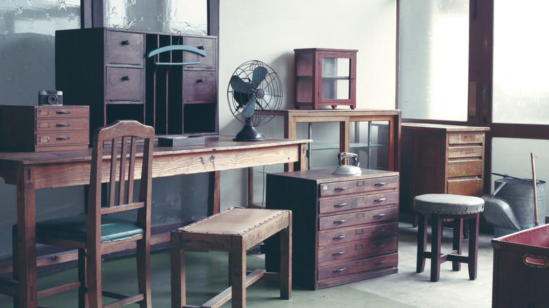 A room filled with tables, cabinets, chairs, and benches