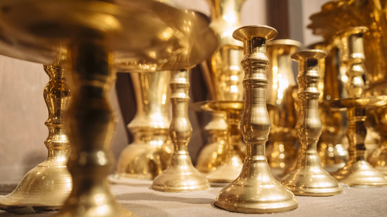 Shelf full of brass candlesticks