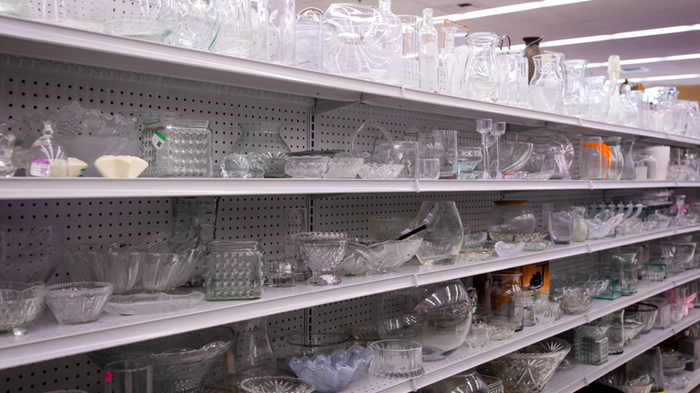 Shelves of glassware at a thrift store