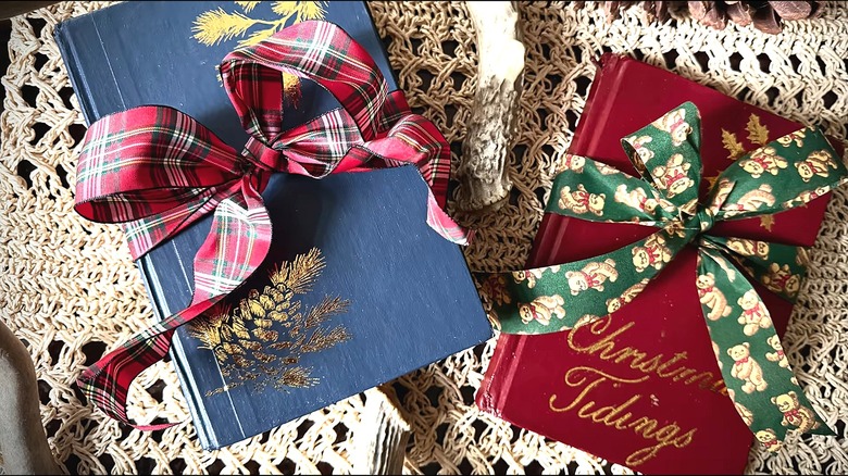 Old books painted with a Christmas theme and tied with a ribbon