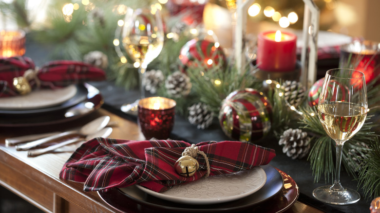Intricately decorated Christmas table with chargers, plaid napkins, and lots of decor