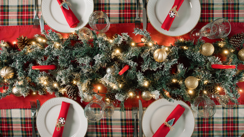 Holiday table with a red, green, and cream plaid tablecloth as the base