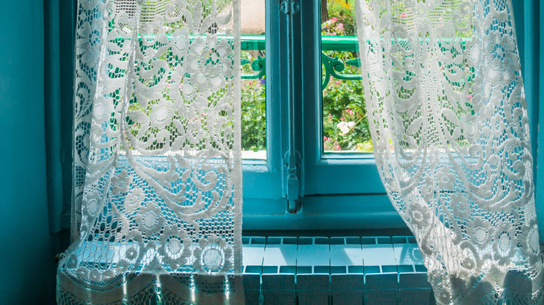 lace curtains on window with blue walls