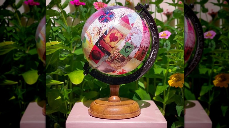A multi-colored découpaged globe with plants