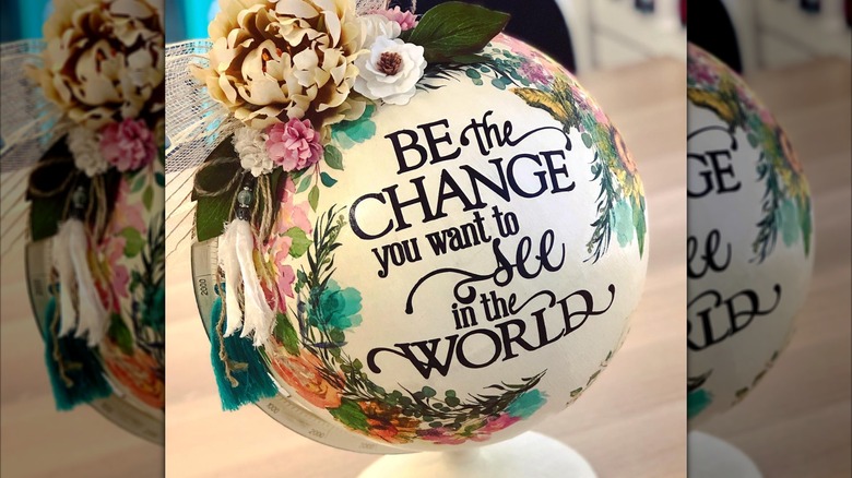 A white a floral altered world globe with inspirational text