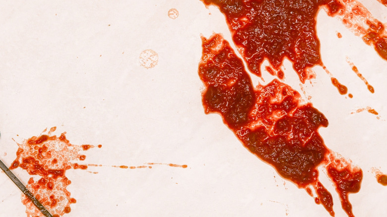 Red sauce splattered on a tile floor