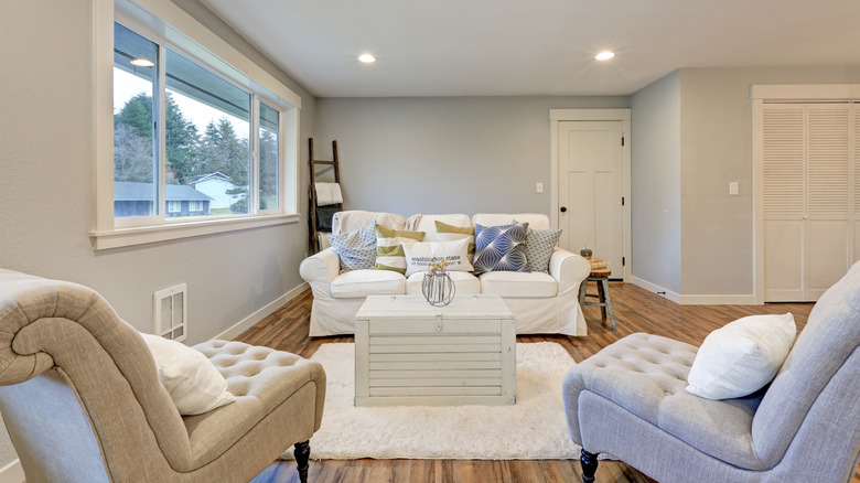Living room seating, including a sofa with a white slipcover and multiple throw pillows