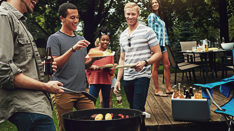 Friends gather around a backyard barbecue