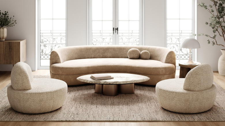 Gray curved furniture in front of french doors.