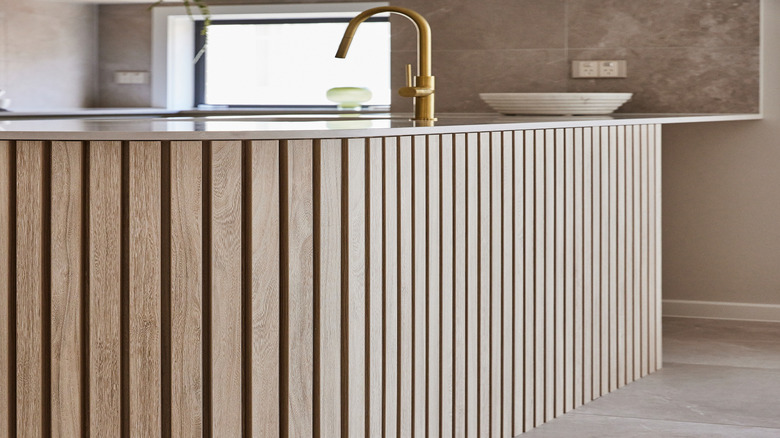 Fluted wood paneling in kitchen base cabinet