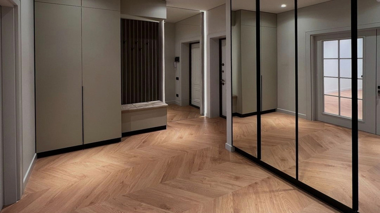 A hallway area with a mirrored wall.