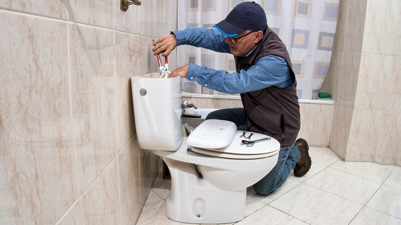Man working on toilet repairs