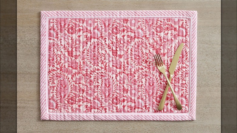 Pink placemat with gold solverware