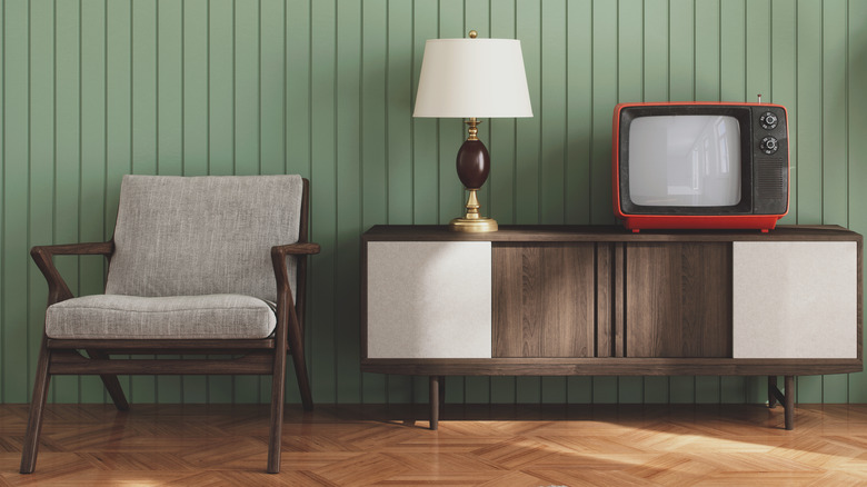 Dark wood furniture displayed against a pistachio-colored wall paneling.