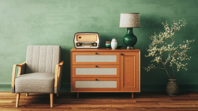 Retro living room with green walls, stylish furniture, and vintage accessories.