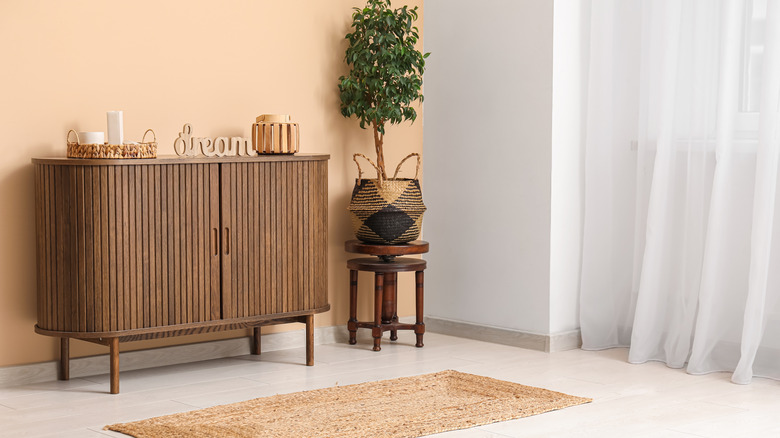 Dark wood console in front of a taupe wall in a living room.