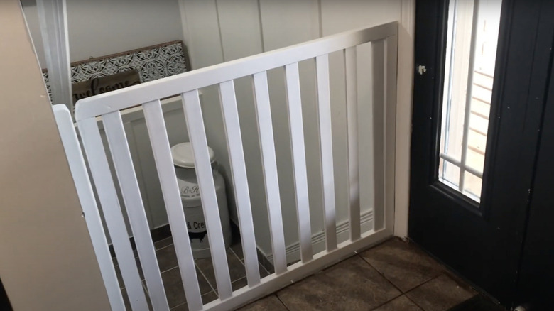 A baby gate made from old deck railing closes off some dangerous basement stairs.