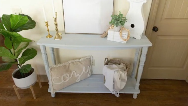 A tall wooden hall table with legs made from porch railing spindles.