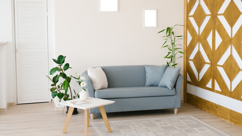 dusty blue couch with khaki walls