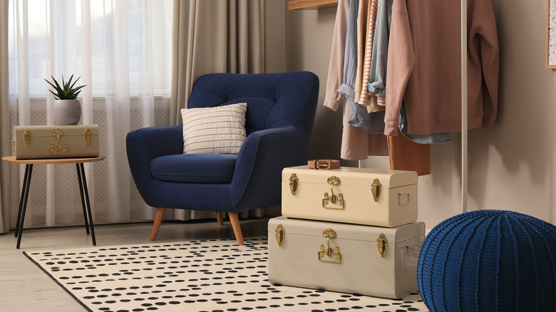 khaki colored wall with navy chair and pouf in a dressing room