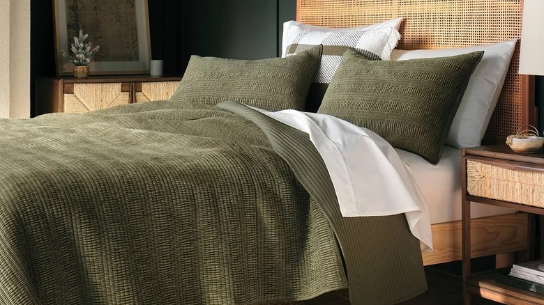 A sumptuous green quilt on a bed