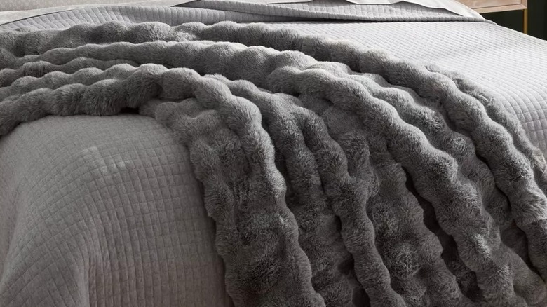 Faux fur blanket draped over a bed
