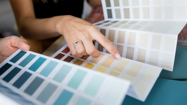 A person pointing at paint samples