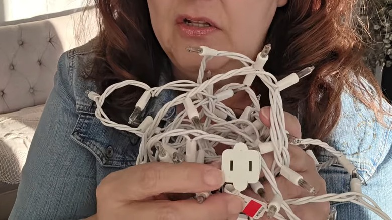 Woman holding burned out white lights in hand