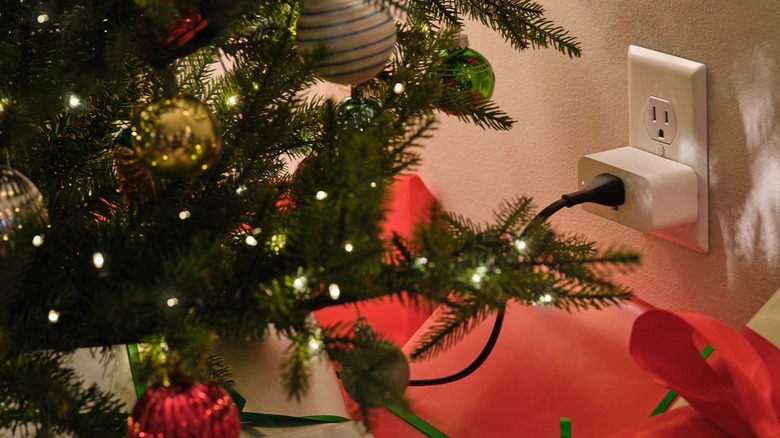 A Christmas tree's lights are plugged in a smart plug