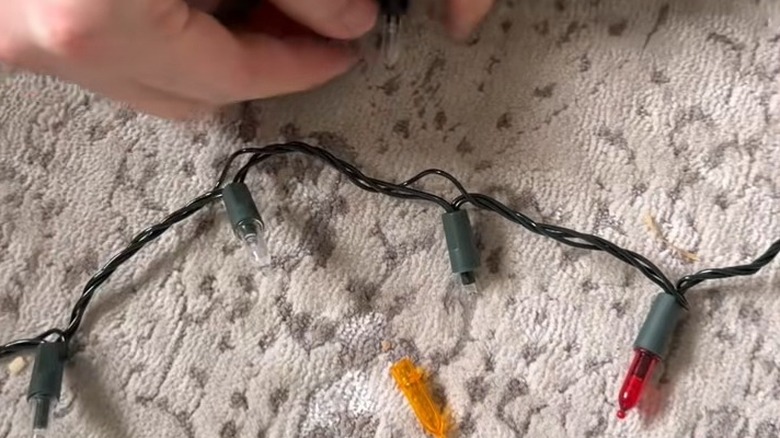 Hand changing the cap over string lights