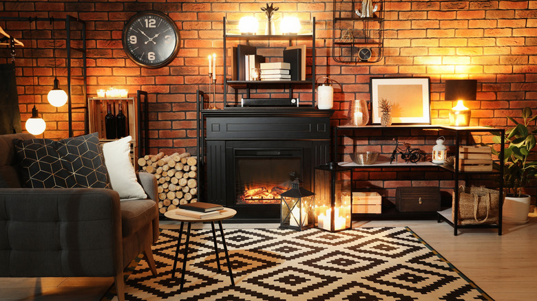 A living room filled with low light sources like lanterns and candles, along with a fireplace.
