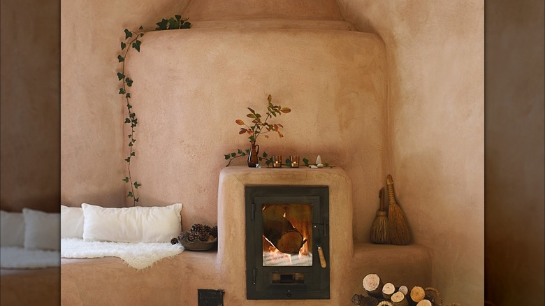A light pink, plaster fireplace with a rounded front and bench.