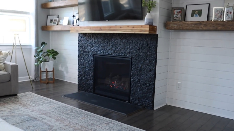 A fireplace painted a steely blue hue in a living room.